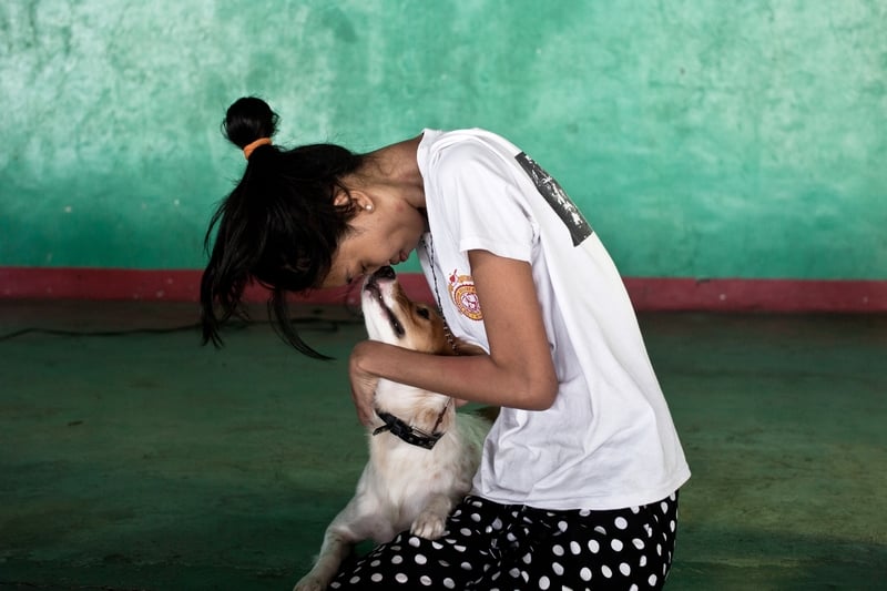 Donna y su perro Zorro aguardan en la clínica gratuita en filipinas para que él sea vacunado contra la rabia