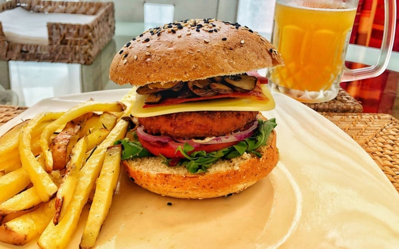 Una hamburguesa vegana con papas fritas y cerveza.